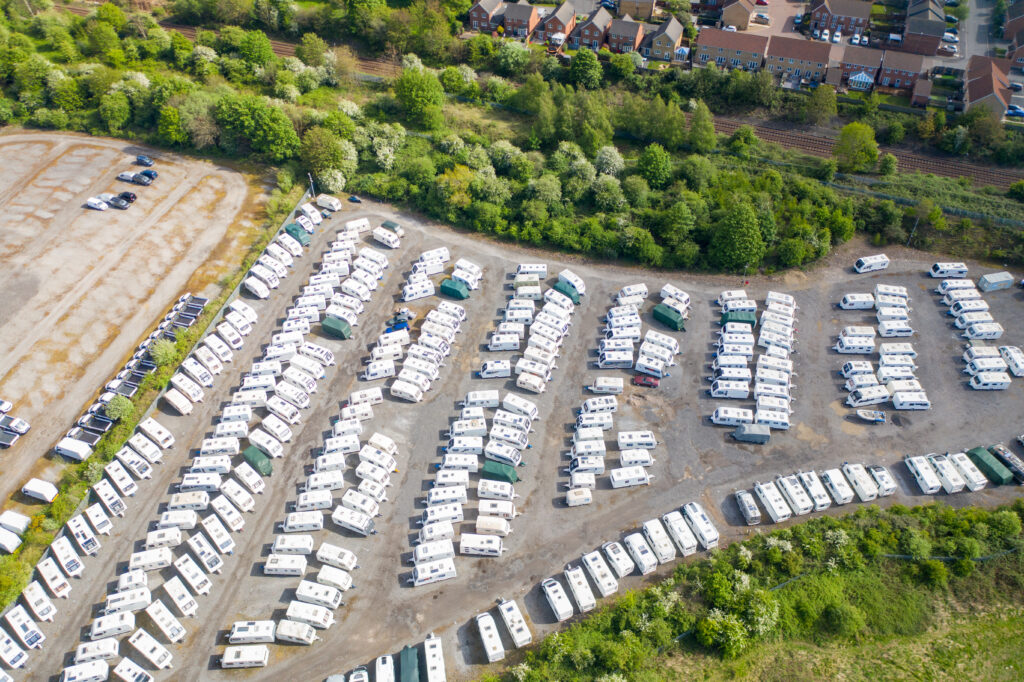 Aerial view of a large outdoor RV storage facility with rows of travel trailers and motorhomes