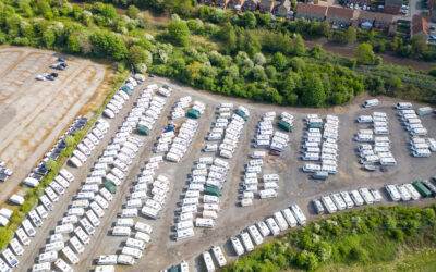 Aerial view of a large outdoor RV storage facility with rows of travel trailers and motorhomes